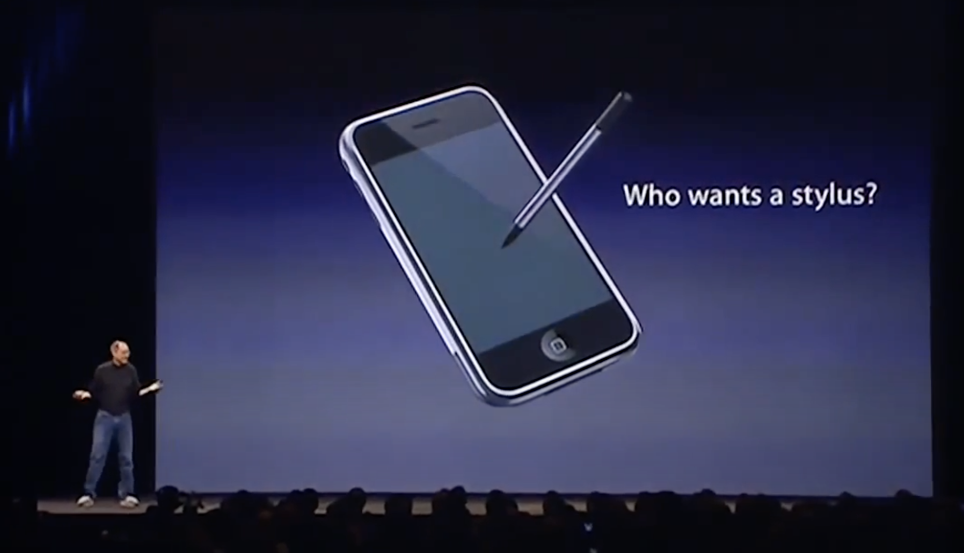 "Who wants a stylus?" と書かれたスライドとスティーブ・ジョブズの写真